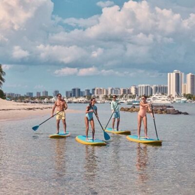 amigos paddleboarding na peanut island. créditos para discover the palm beaches.