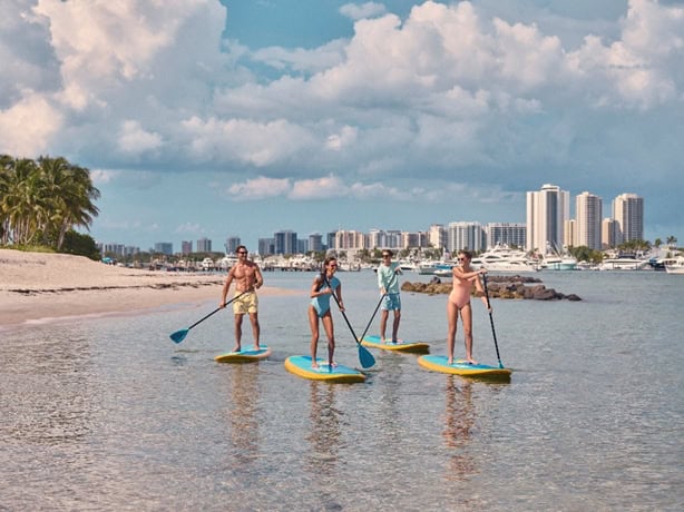 amigos paddleboarding na peanut island. créditos para discover the palm beaches.