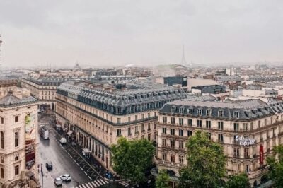 Vistas de Paris com edifícios históricos e a Torre Eiffel ao fundo, ideal para viagens e turismo na França.