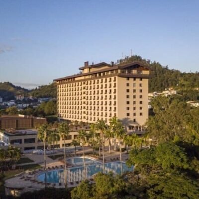 SuoViaggio hotel de luxo com piscina e vista panorâmica em área arborizada, ideal para viagens de lazer e negócios na cidade.