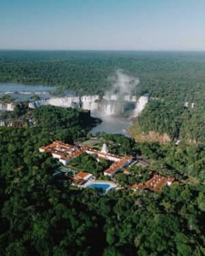 Vista aérea da Cachoeira do Iguaçu, em Foz do Iguaçu, com resort luxuoso, piscina, e ampla vegetação, ideal para turismo ecológico, viagens de lazer e aventura na natureza.