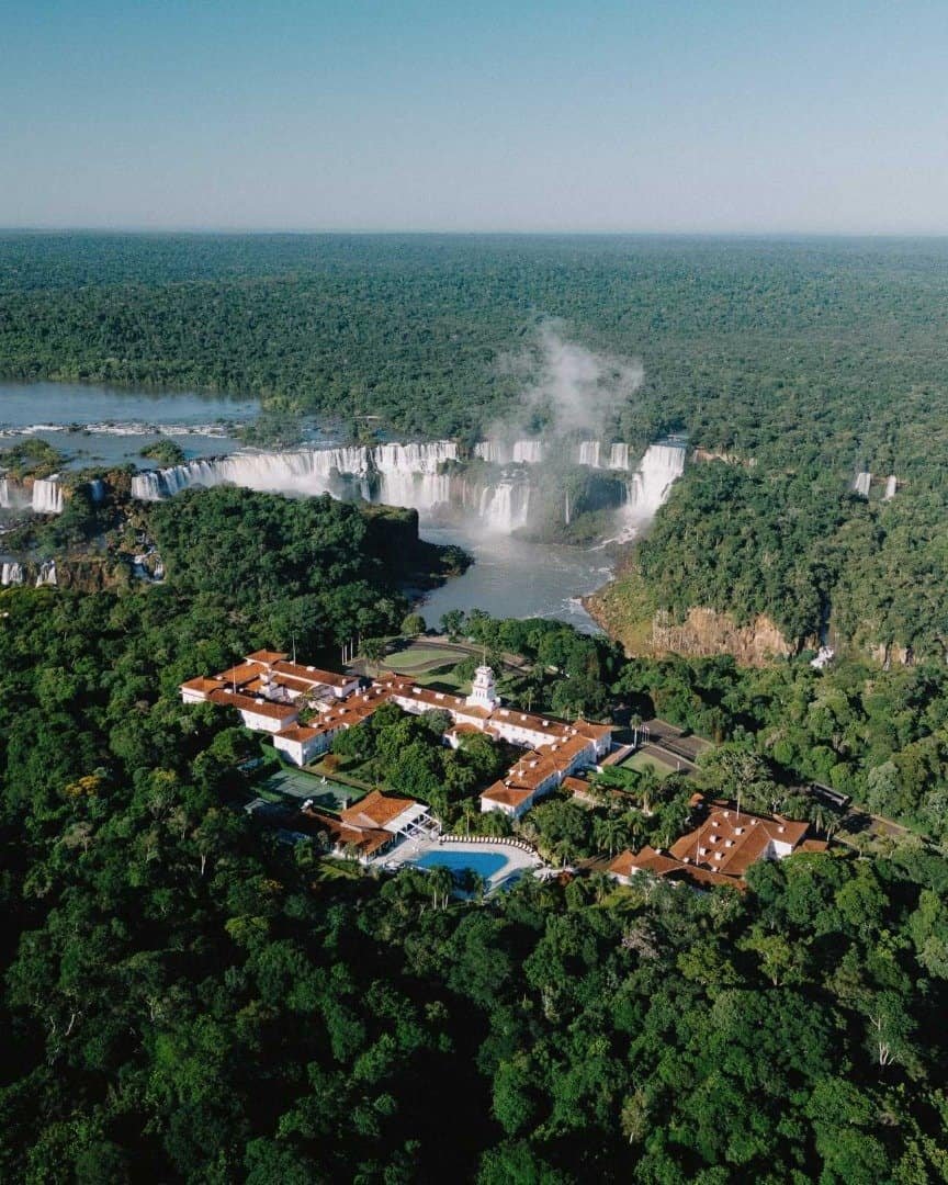 Vista aérea da Cachoeira do Iguaçu, em Foz do Iguaçu, com resort luxuoso, piscina, e ampla vegetação, ideal para turismo ecológico, viagens de lazer e aventura na natureza.