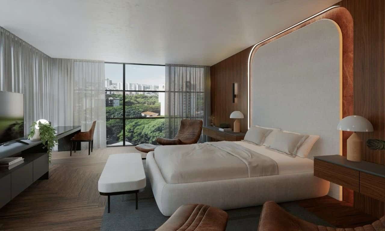 Foto de um quarto de hotel moderno com cama king size, iluminação suave, painel de madeira, janela grande com vista para a cidade e área de lazer confortável, ambiente ideal para relaxar em viagens de lazer ou negócios.