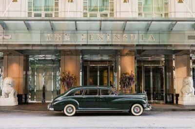 SuoViaggio, hotel de luxo em São Paulo, fachada do The Peninsula com carro clássico na entrada, ambiente sofisticado, perfeito para viagens de lazer ou negócios, experiência exclusiva e conforto premium.