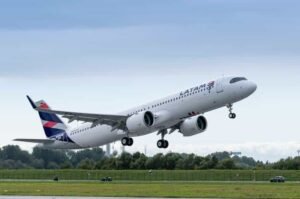 Avião da LATAM Airlines em decolagem com céu claro, viagem aérea segura e confortável.