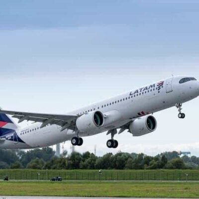 Avião da LATAM Airlines em decolagem com céu claro, viagem aérea segura e confortável.