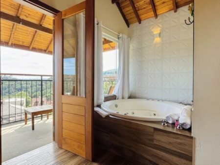 4 suíte da hospedagem com varanda e banheira de hidromassagem com vista para a área externa