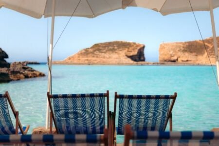 Praia paradisíaca com espreguiçadeiras e vista para o mar 4 lagoa azul – comino