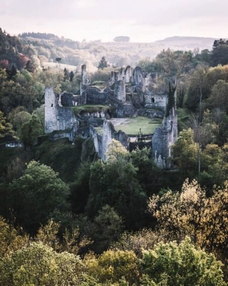 Castelo em ruínas rodeado por vegetação exuberante em paisagem natural. 5 instagram pic of the month credits @canipel